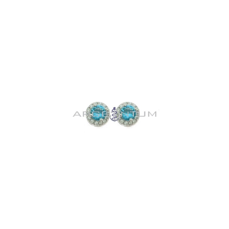 Lobe earrings ø 6 mm with central round blue zircon in a frame of white zircons plated white gold in 925 silver